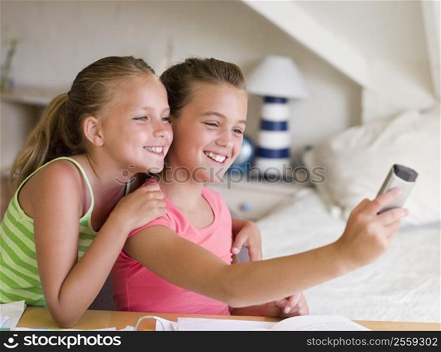 Young Girls Distracted From Their Homework, Playing With A Cellphone