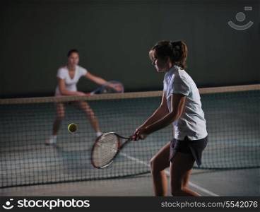 young girls playing tennis game indoori in tennis court