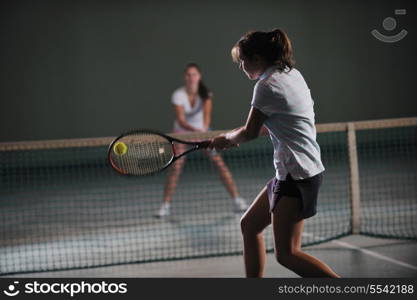 young girls playing tennis game indoori in tennis court