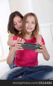 Young girls playing with gaming console on sofa