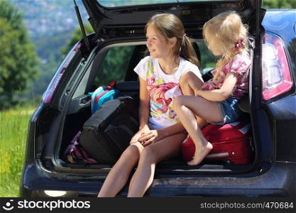 young girls portrait at the car trunk