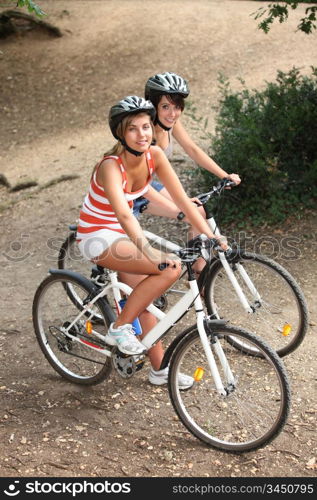 Young girls riding bikes in the woods