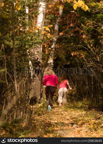Young girls running in a forest