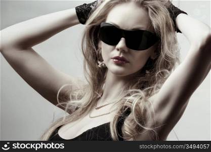 young gorgeous blonde wearing sunglasses posing in the studio