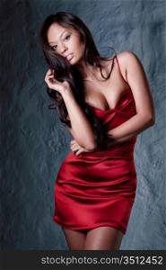 young gorgeous brunette in red evening dress posing