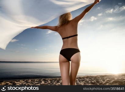 young gorgeous caucasian blonde model posing at sunset on the beach