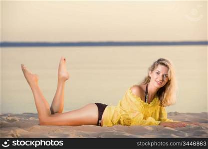 young gorgeous caucasian blonde posing at sunset on the beach