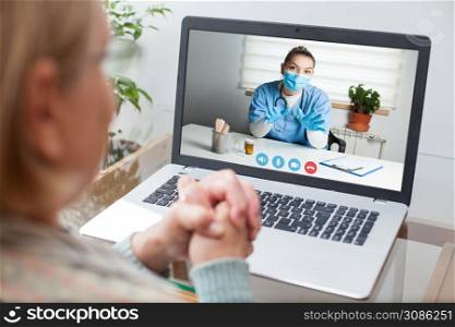 Young GP physician and elderly female patient consulting over video call,virtual medical health check-up,doctor televisit instead of in-office appointment during COVID-19 pandemic outbreak lockdown