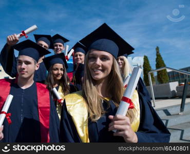 young graduates students group standing in front of university building on graduation day