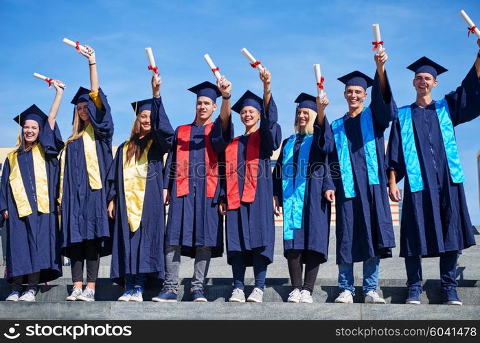 young graduates students group standing in front of university building on graduation day