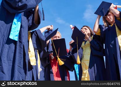 young graduates students group standing in front of university building on graduation day