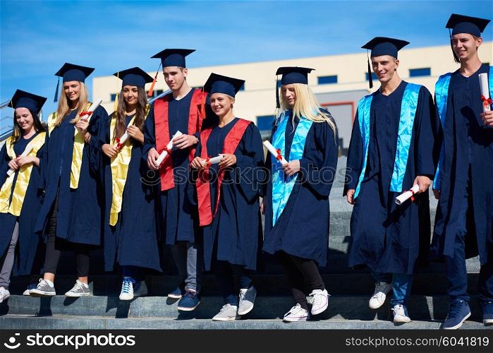 young graduates students group standing in front of university building on graduation day