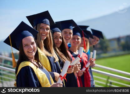 young graduates students group standing in front of university building on graduation day