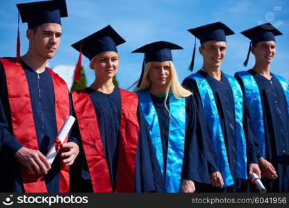 young graduates students group standing in front of university building on graduation day