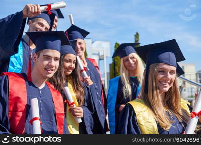 young graduates students group standing in front of university building on graduation day