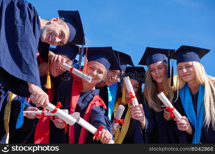 young graduates students group standing in front of university building on graduation day