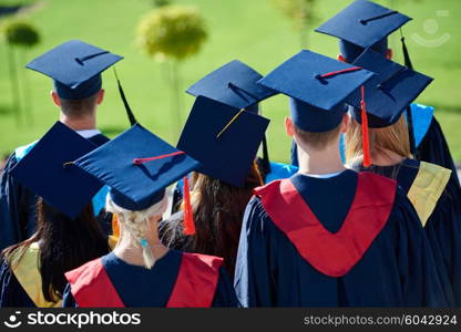 young graduates students group standing in front of university building on graduation day