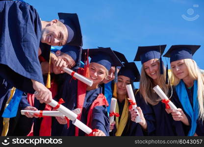 young graduates students group standing in front of university building on graduation day