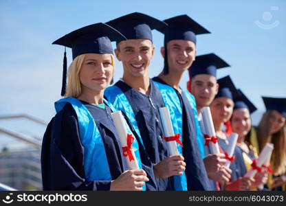 young graduates students group standing in front of university building on graduation day