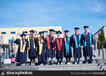 young graduates students group standing in front of university building on graduation day