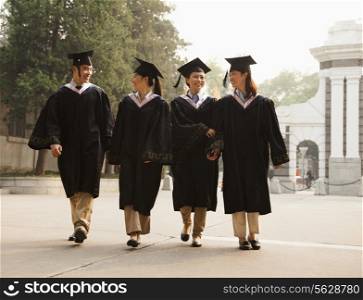 Young Graduates Walking Across Campus
