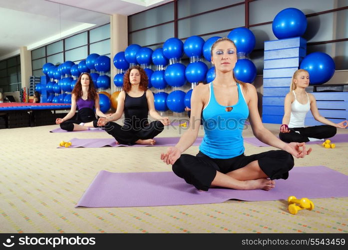 young group of girls exercising yoga in lotus flower position