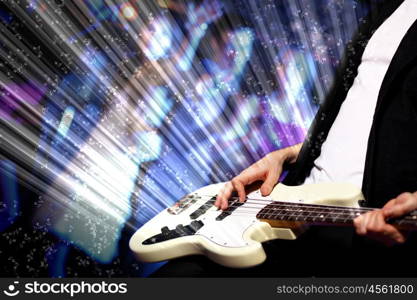 Young guitar player with instrument performing in night club