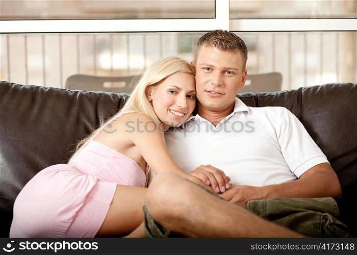 Young guy and lady emracing, while facing camera and relaxing