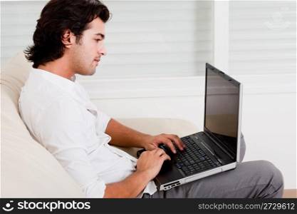 young guy doing work in sofa working at home