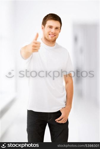 young guy in blank white t-shirt showing thumbs up