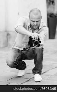 young guy, photographer walking in the old streets poland of europe