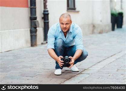 young guy, photographer walking in the old streets poland of europe