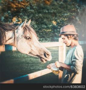Young guy with horse holds a beer mug in his hand