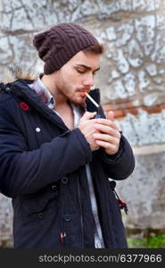Young guy with wool cap smoking in the street