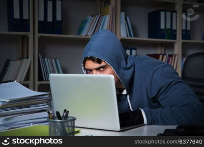 Young hacker hacking into computer at night