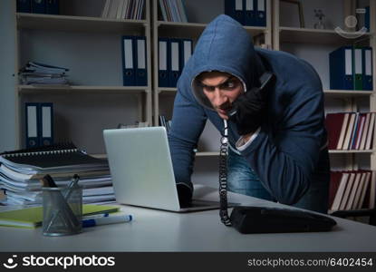 Young hacker hacking into computer at night