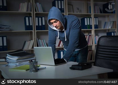 Young hacker hacking into computer at night