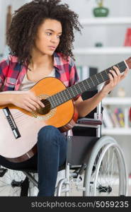 young handicapped guitarist woman sitting on wheelchair
