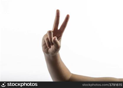 Young hands makes a gesture: victory sign with two fingers