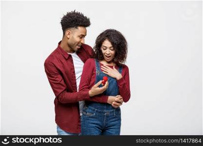 Young handsome african american man surprisingly ask her girlfriend for proposal. Young handsome african american man surprisingly ask her girlfriend for proposal.
