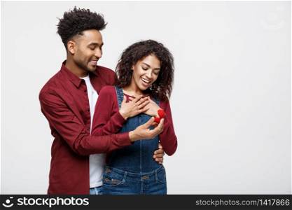 Young handsome african american man surprisingly ask her girlfriend for proposal. Young handsome african american man surprisingly ask her girlfriend for proposal.