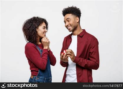 Young handsome african american man surprisingly ask her girlfriend for proposal.. Young handsome african american man surprisingly ask her girlfriend for proposal