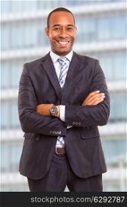 Young handsome african business man posing in front of a modern building
