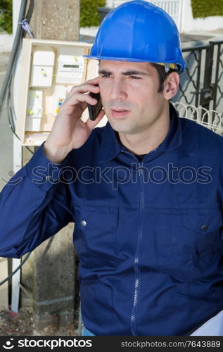 young handsome architect talking on cell phone outdoors