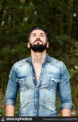 Young handsome bearded hipster man in the field