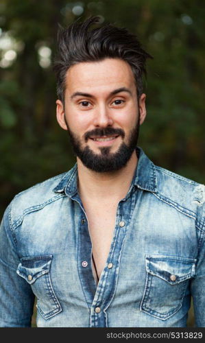 Young handsome bearded hipster man in the field