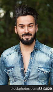 Young handsome bearded hipster man in the field