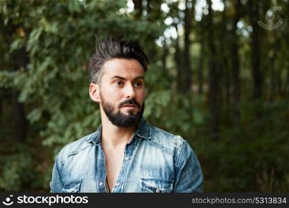 Young handsome bearded hipster man in the field