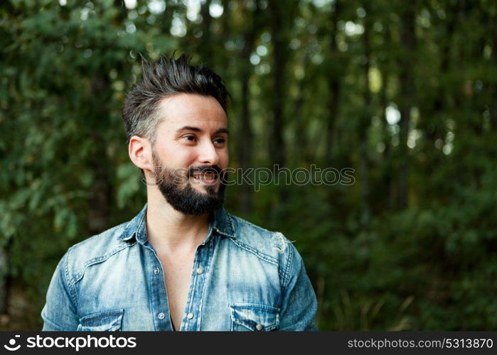 Young handsome bearded hipster man in the field