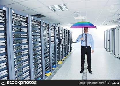 young handsome business man engineer in &#xA;businessman hold rainbow colored umbrella in server datacenter room and representing security and antivirus sofware protection concept